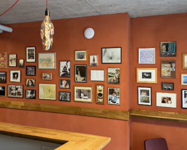 Das Foto zeigt Bilder an der Wand der Bar, die Bewohnende der Winkelhalden ausgewählt haben.