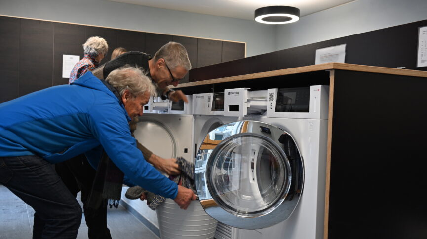 Zwei Männer entleeren eine Waschmaschine